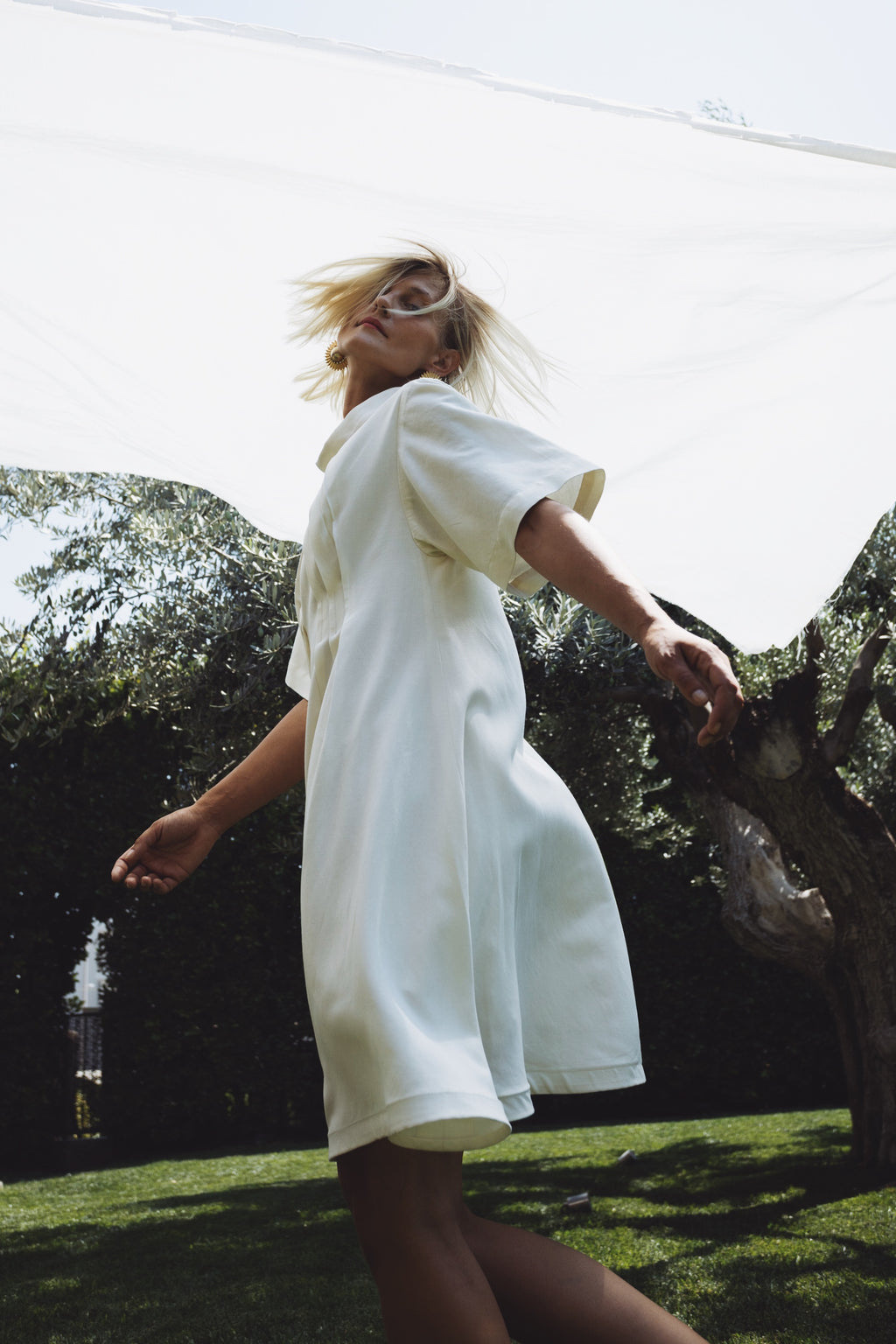 Cream linen-cotton dress in motion with soft A-line silhouette