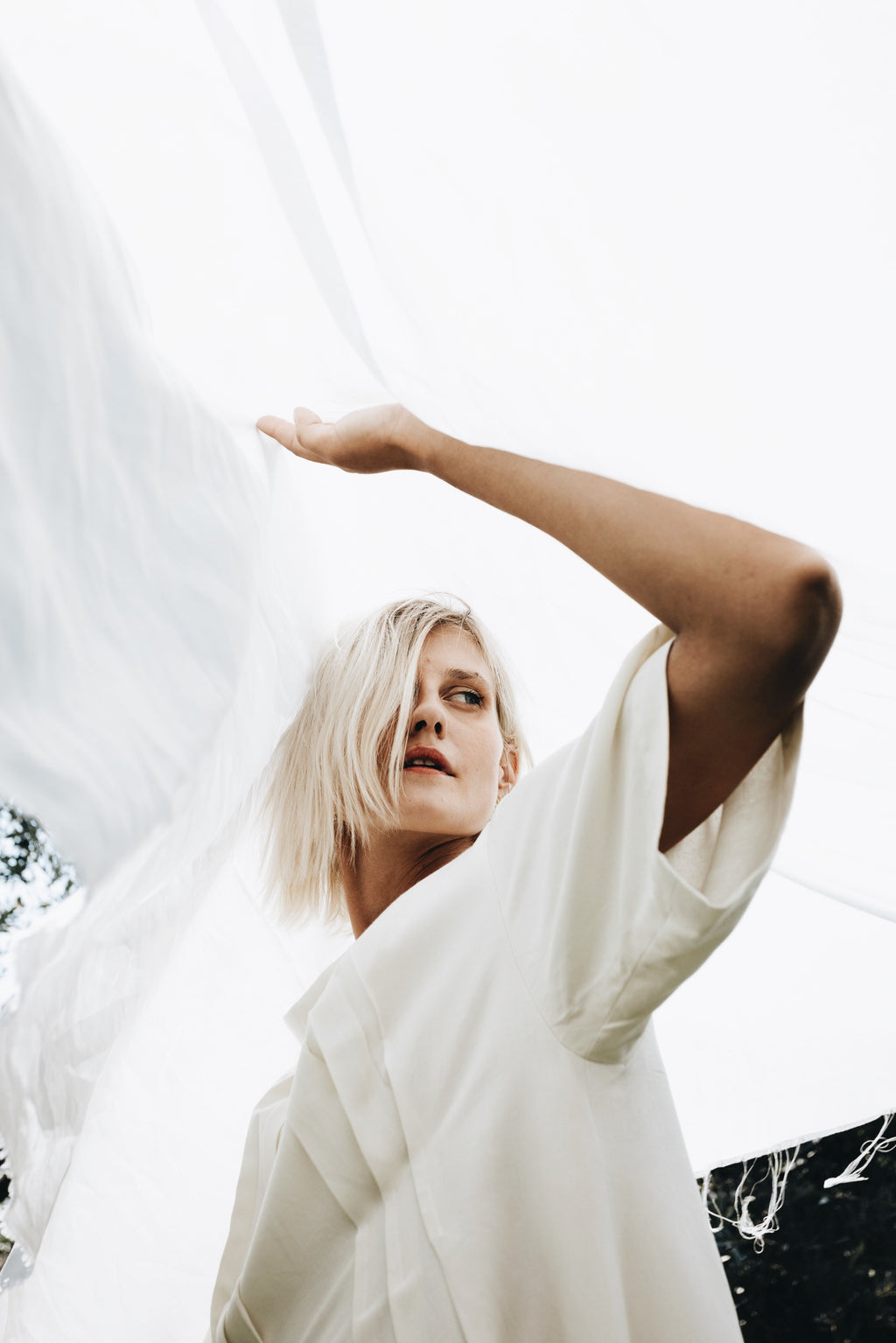 Cream linen-cotton dress with soft flowing fabric detail in natural light