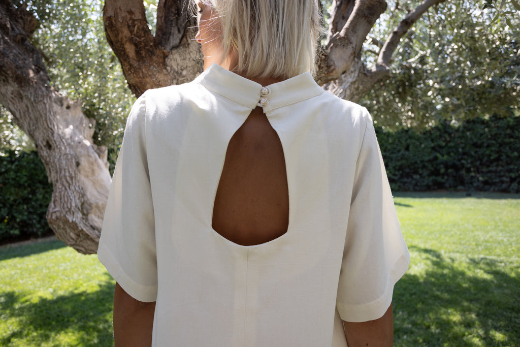 Cream linen-cotton dress with open back detail in natural light