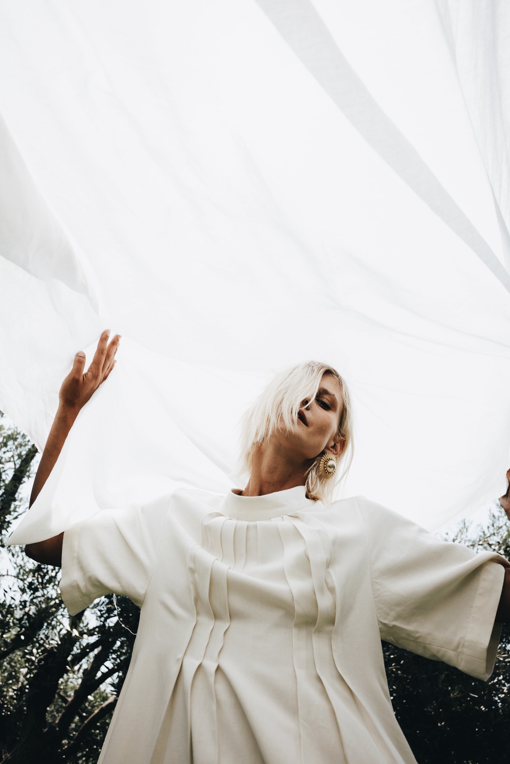 Cream linen-cotton dress with front pleats detail in soft natural light