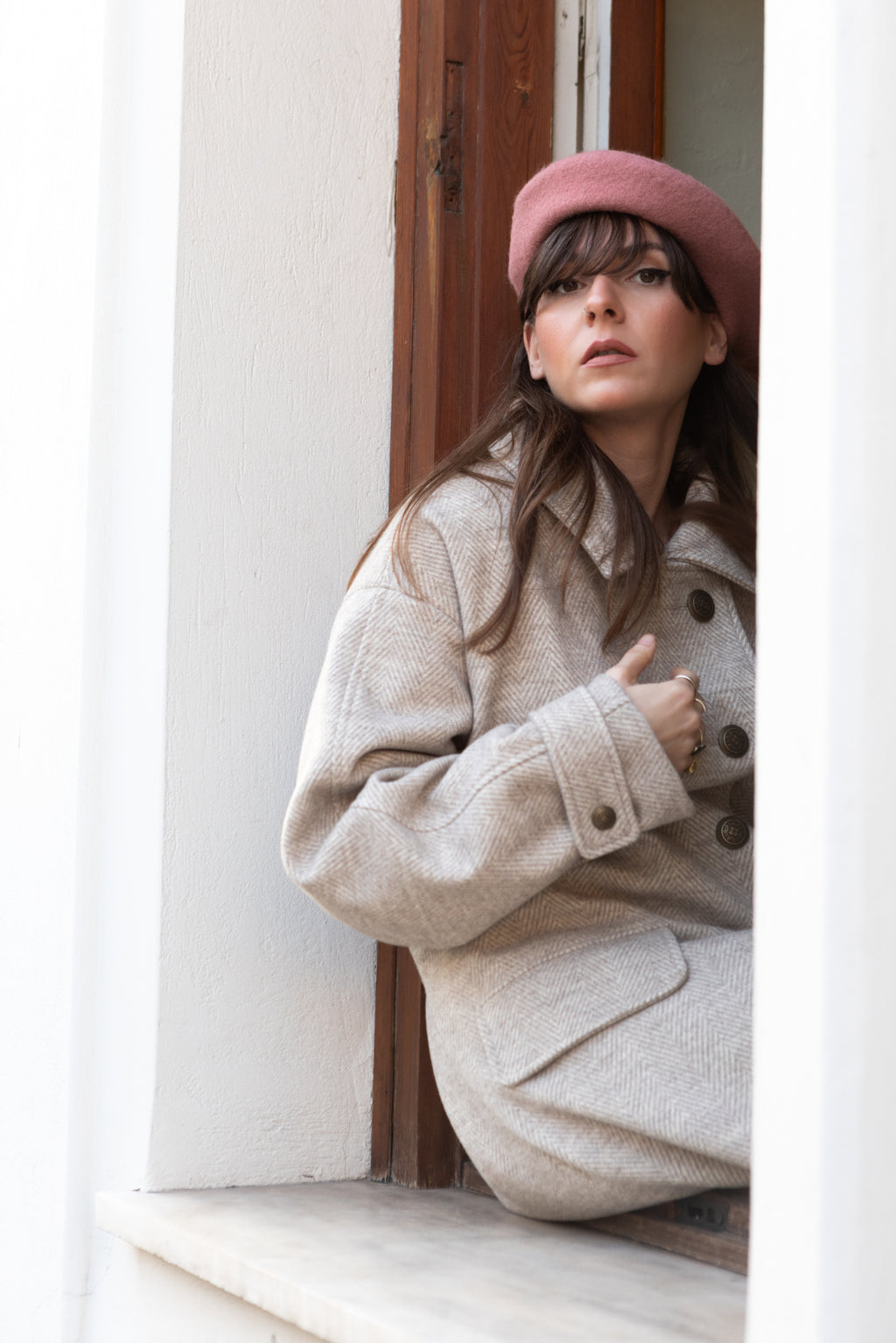 Convertible Collar Coat – oversized wool herringbone coat, seated pose, model wearing pink beret, side detail view, FW25-26 Julia Valas