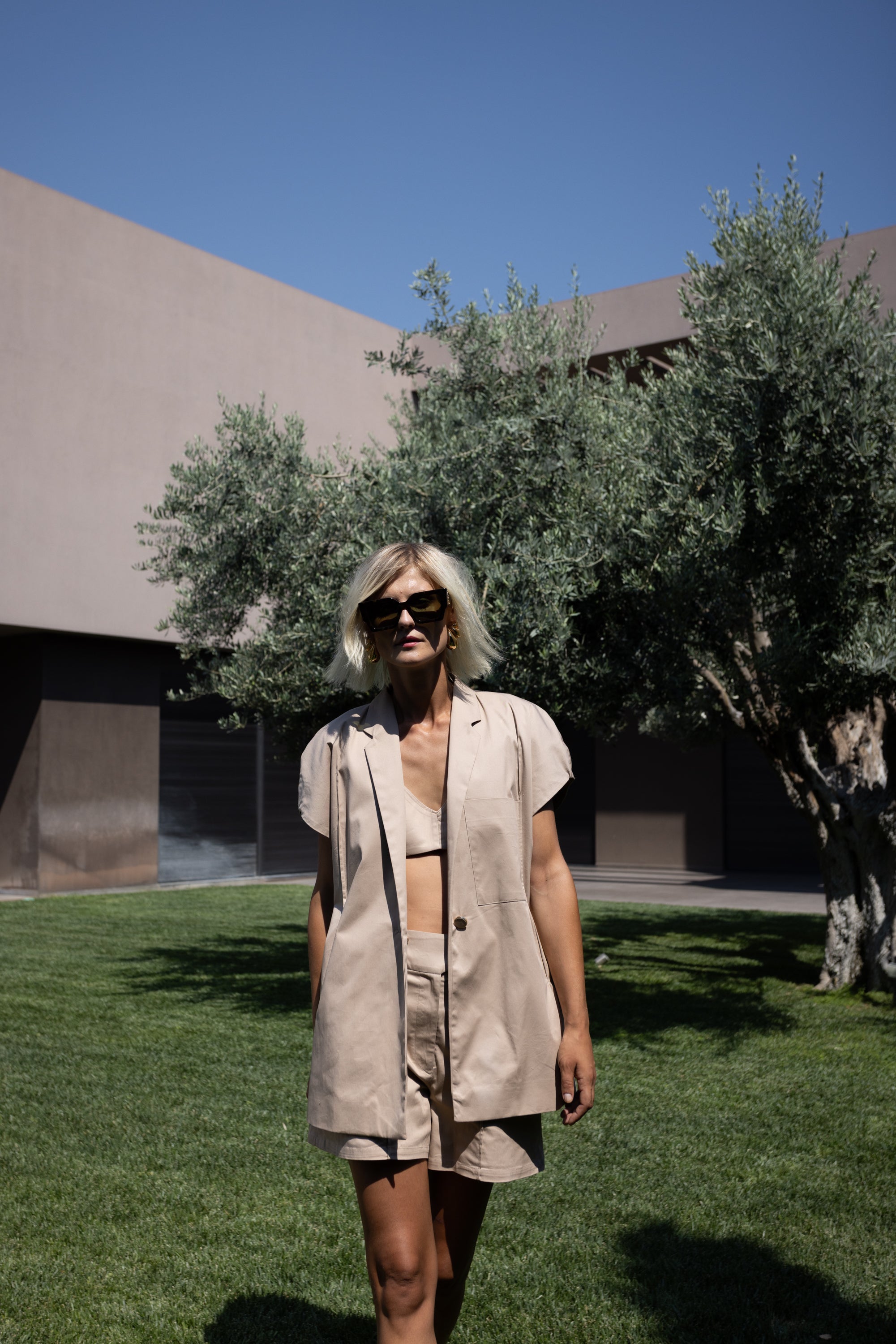 Woman walking outdoors wearing oversized cotton Halo blazer with short sleeves and matching set