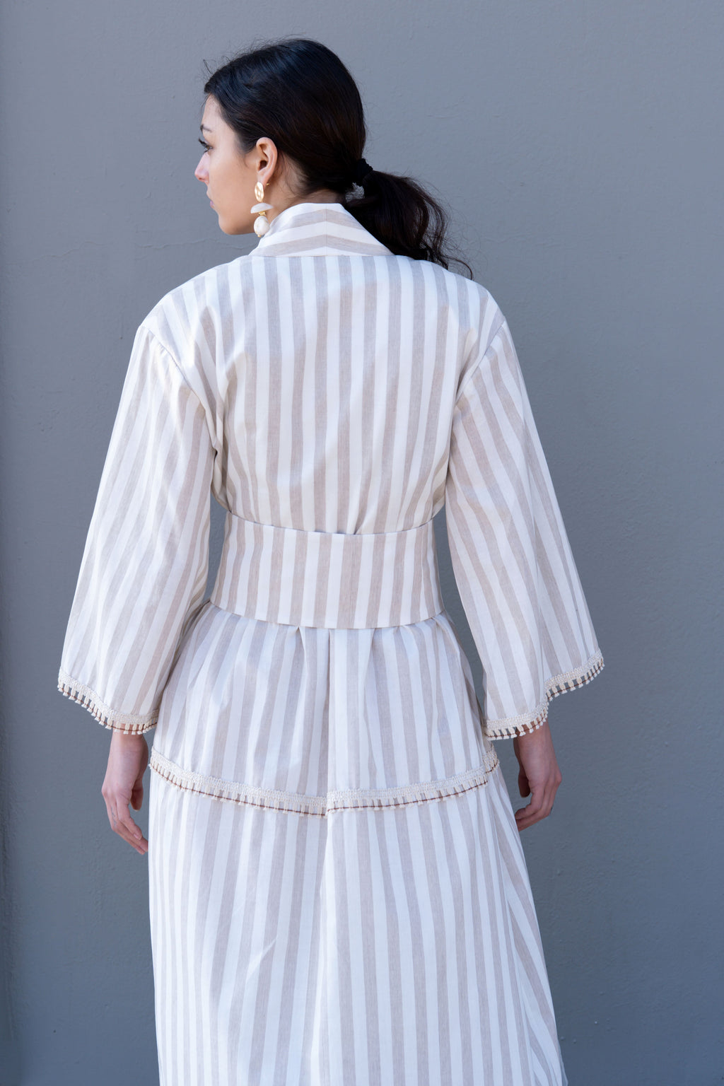 Striped cotton kimono dress back view with wide belt, structured waist and relaxed sleeves, minimal studio background