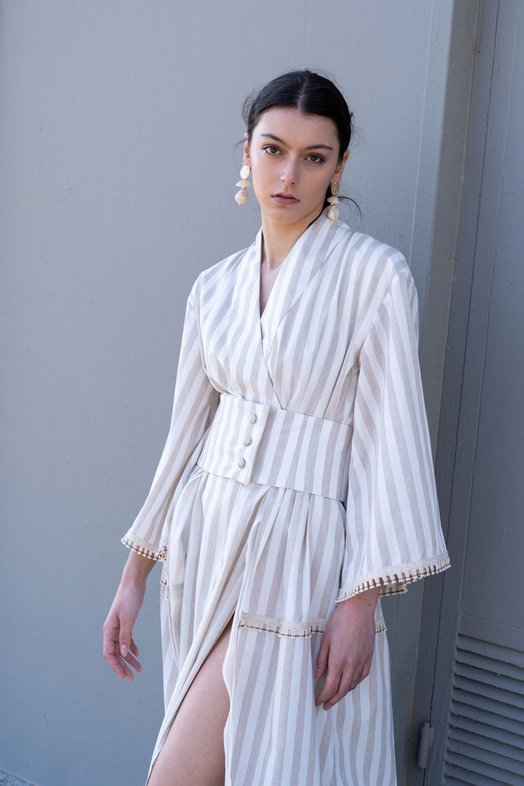 Striped cotton kimono dress front angle with deep slit, wide waist belt and button detail, lightweight summer design with soft movement