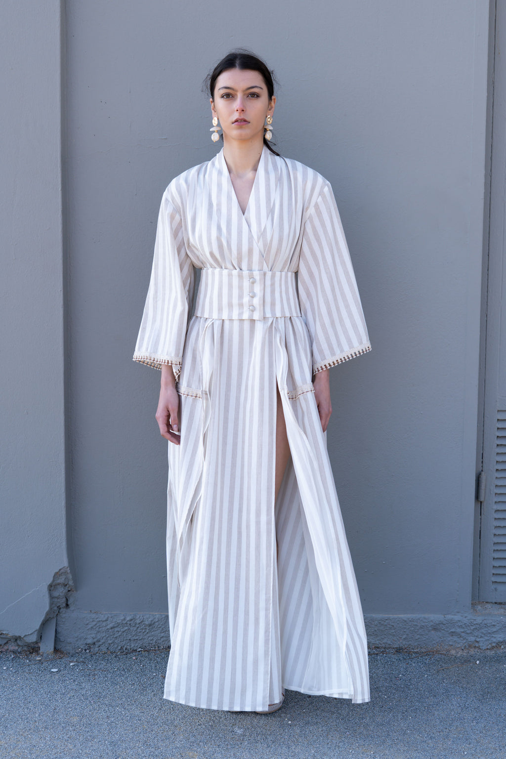 Striped cotton kimono dress front view with wide waist belt, long sleeves and high side slit, minimal structured silhouette