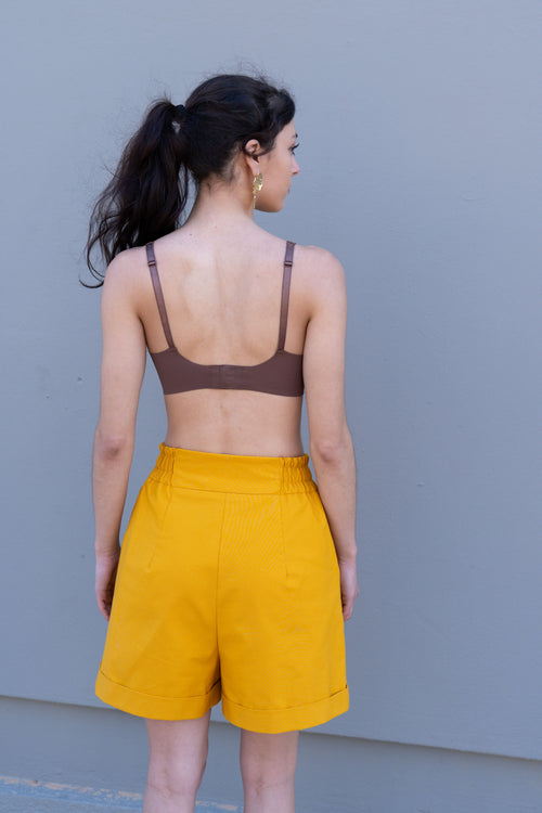 Canary yellow tailored bermuda shorts back view with elastic waistband and relaxed A-line silhouette