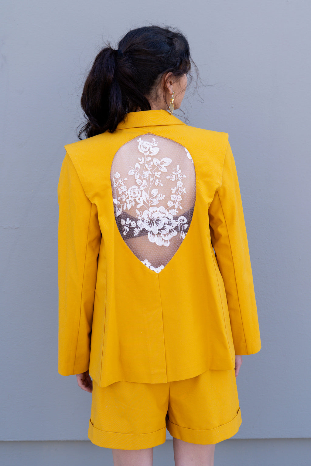 canary yellow tailored blazer with detachable sleeves open back teardrop cutout and embroidered floral lace detail