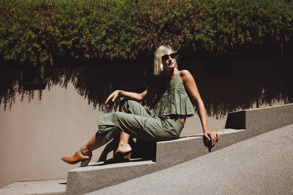 Julia Valas Elia Top with olive capri trousers matching set in relaxed summer pose under natural sunlight