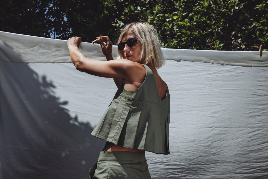 Julia Valas Elia Top olive pleated crop top back view in natural sunlight showing movement and structure