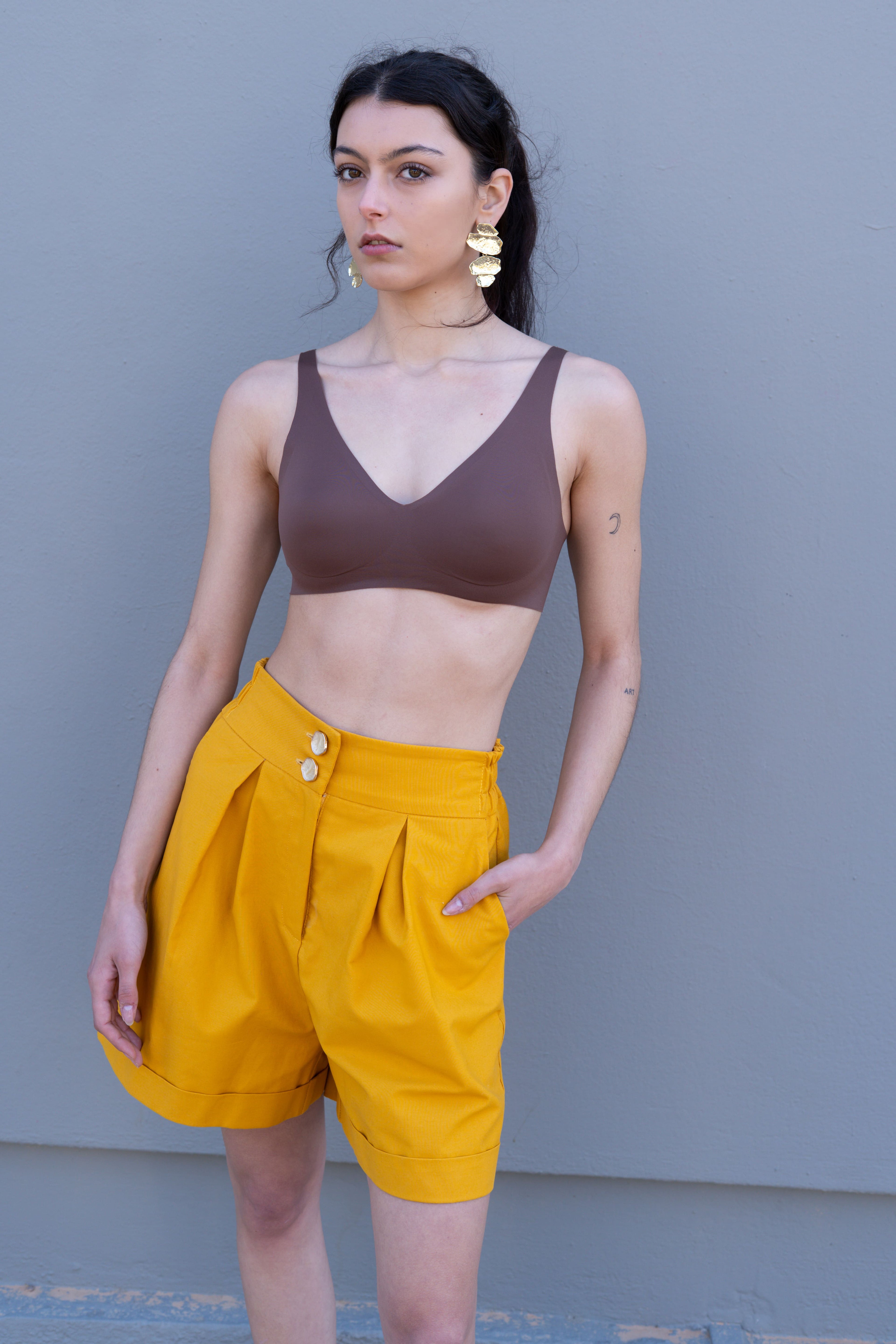 Canary yellow high-waisted tailored bermuda shorts with pleats and double button closure, relaxed A-line silhouette front view