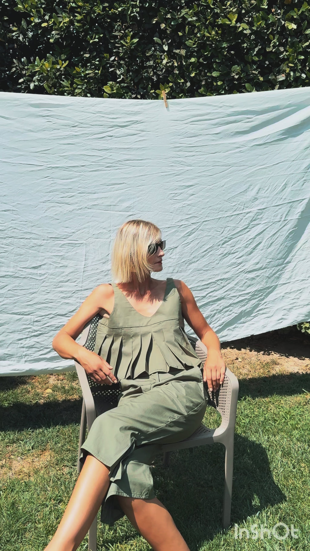 Julia Valas Elia Top olive pleated crop top in natural setting with soft movement among greenery