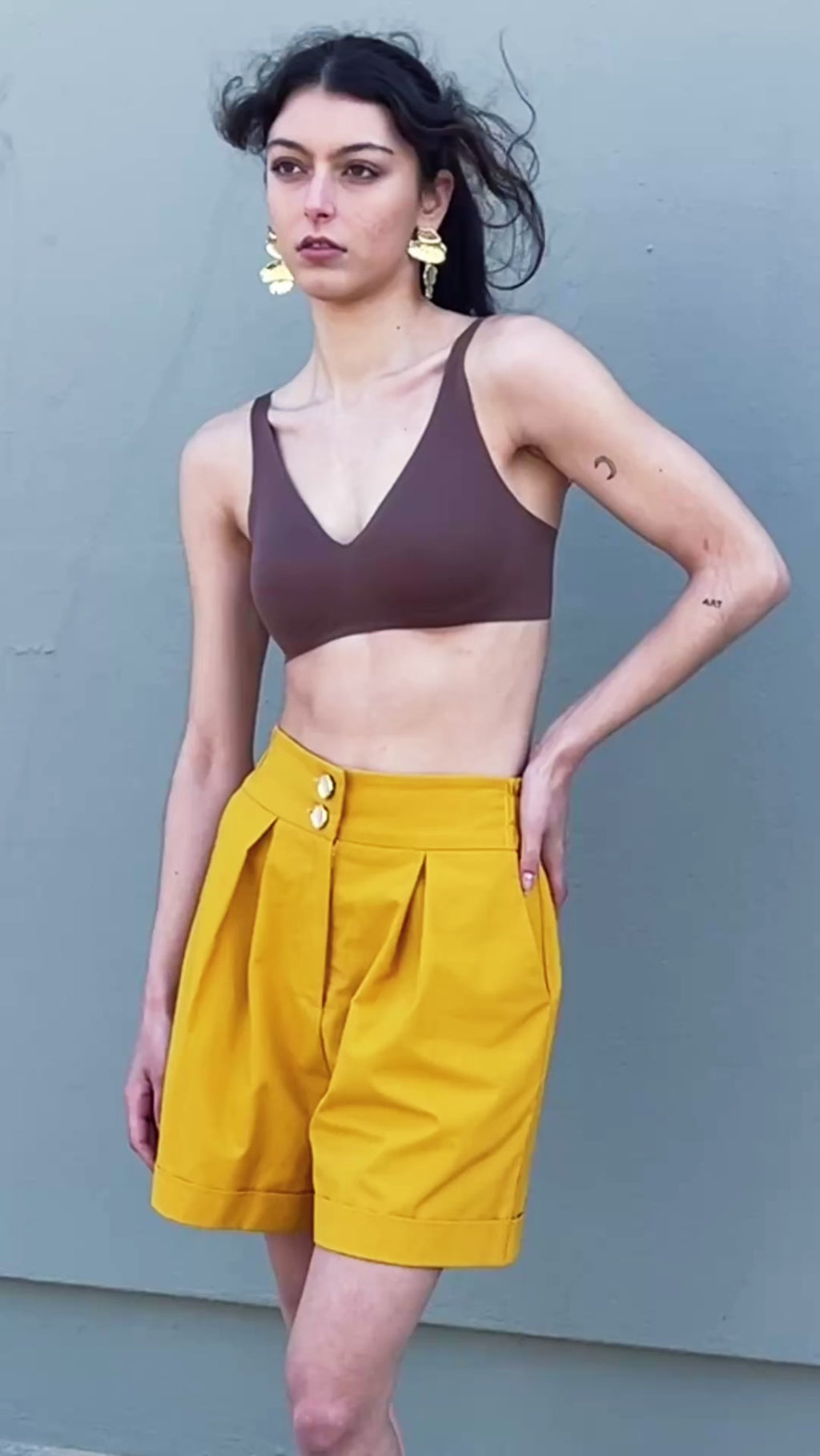 Canary yellow high-waisted tailored bermuda shorts with pleats and double button closure, relaxed A-line silhouette front view, Video