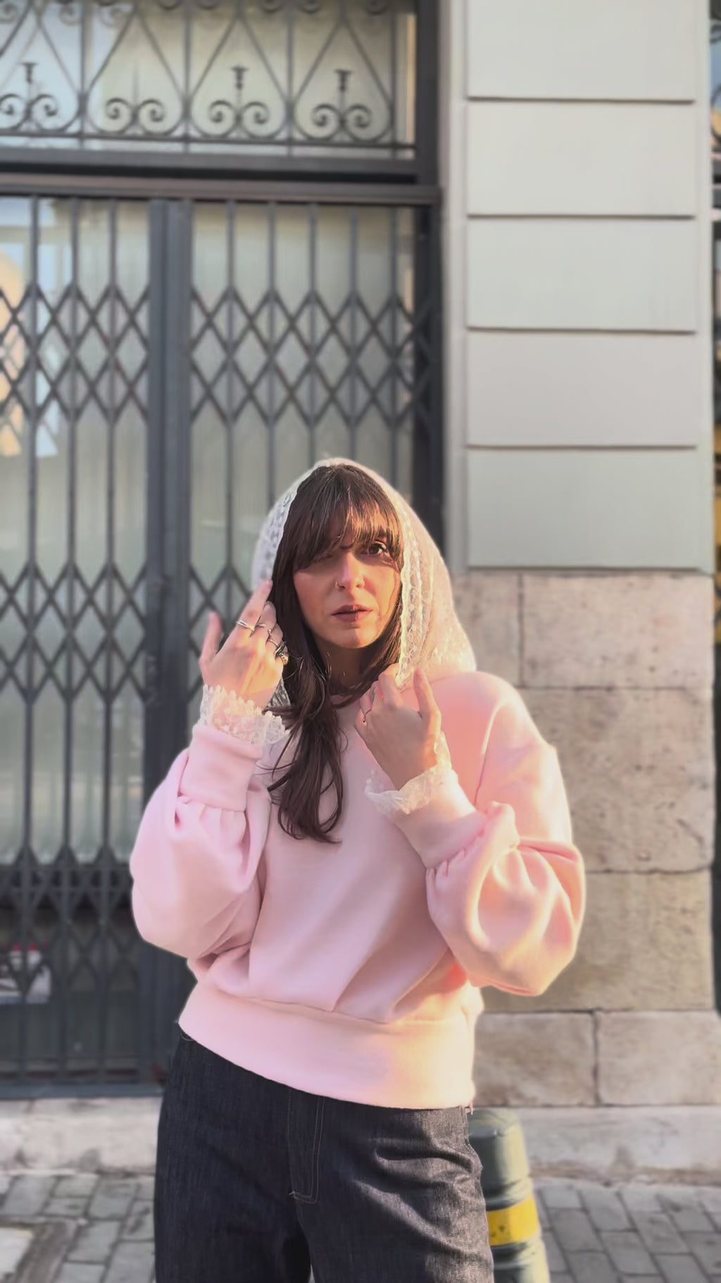 Woman walking in city street wearing soft pink cotton lace hoodie with lace cuffs, relaxed fit casual movement, urban lifestyle video, Julia Valas