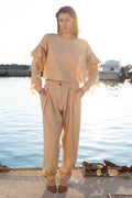Relaxed linen viscose ruffled top with detachable sleeves and flowing draped details paired with pleated loose-fit trousers, minimal resort womenswear by Julia Valas
