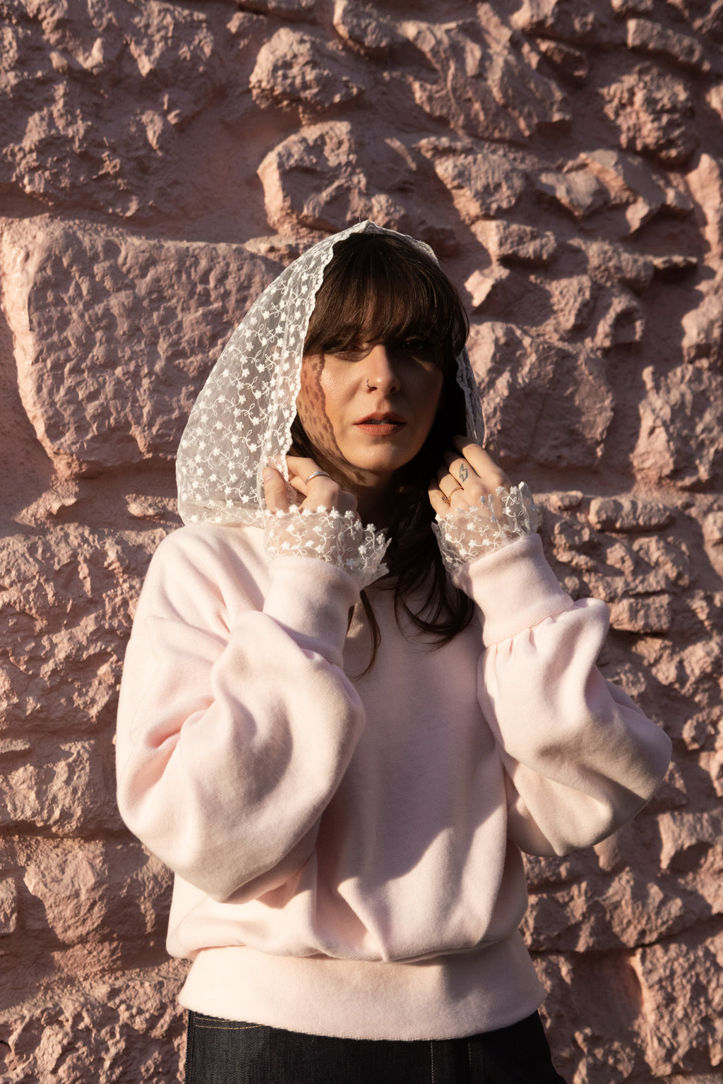 Woman wearing a soft pink cotton hoodie with lace hood and lace cuffs, Julia Valas
