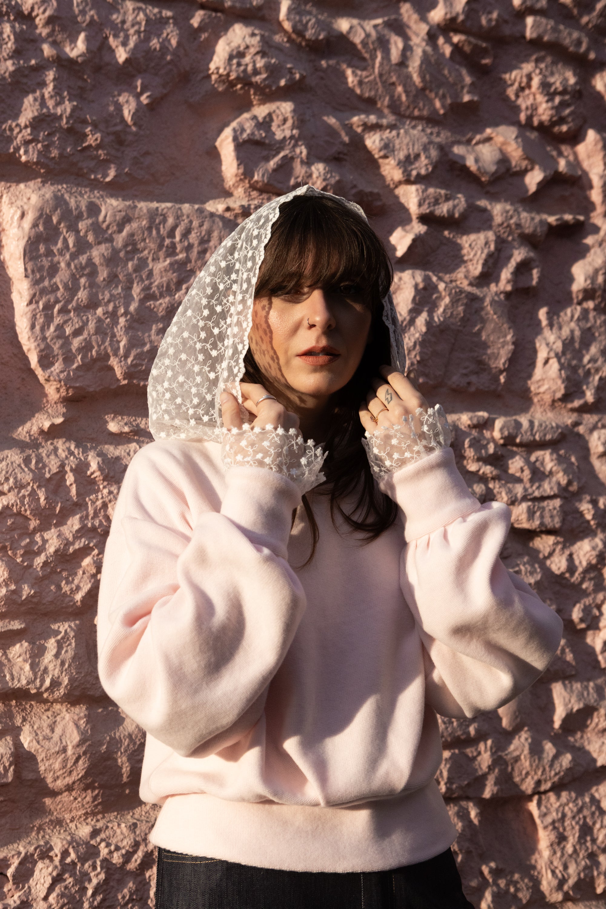 Woman wearing a soft pink cotton hoodie with lace hood and lace cuffs, Julia Valas