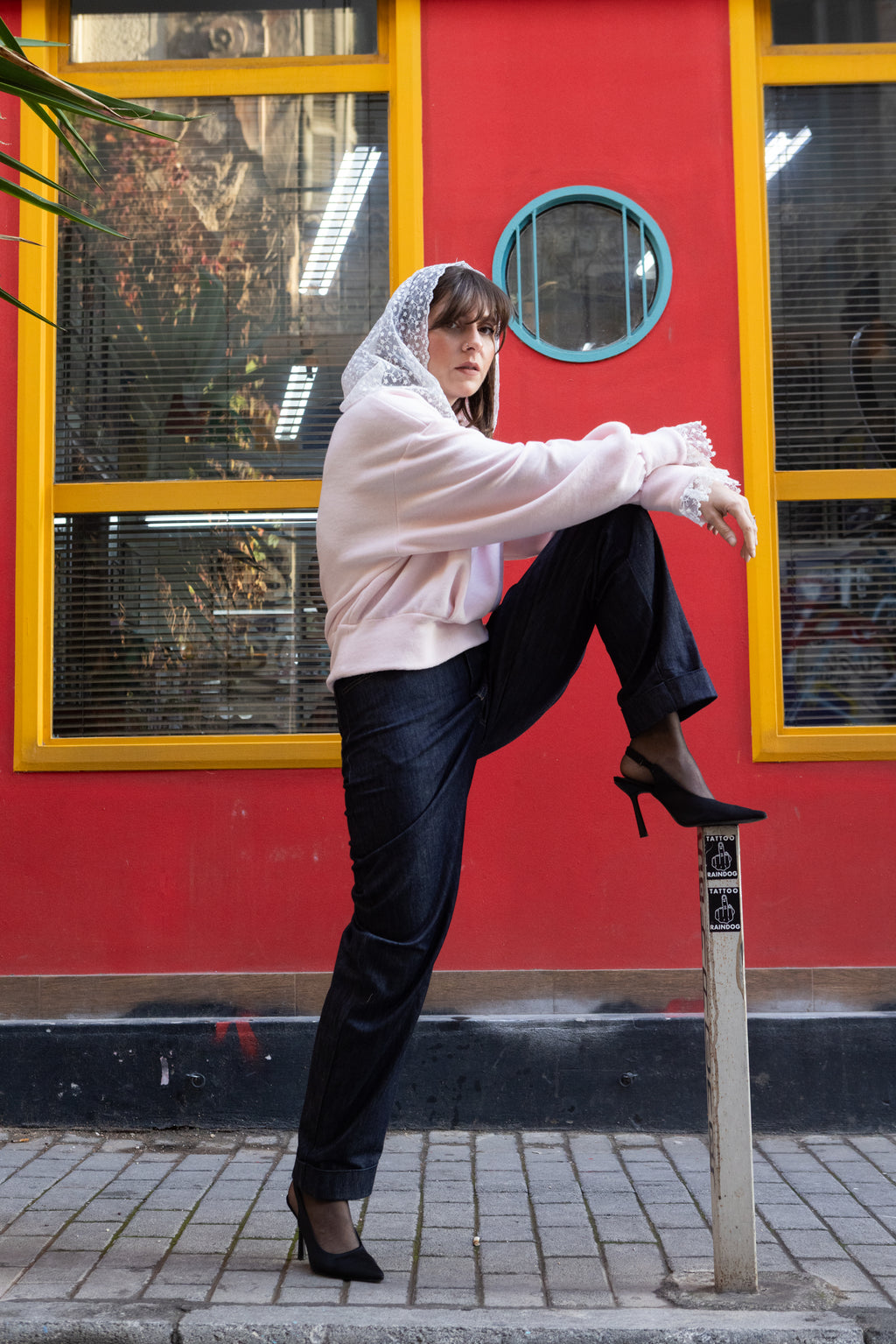 Woman wearing a soft pink cotton lace hoodie with lace hood and cuffs, styled with black trousers and heels, Julia Valas
