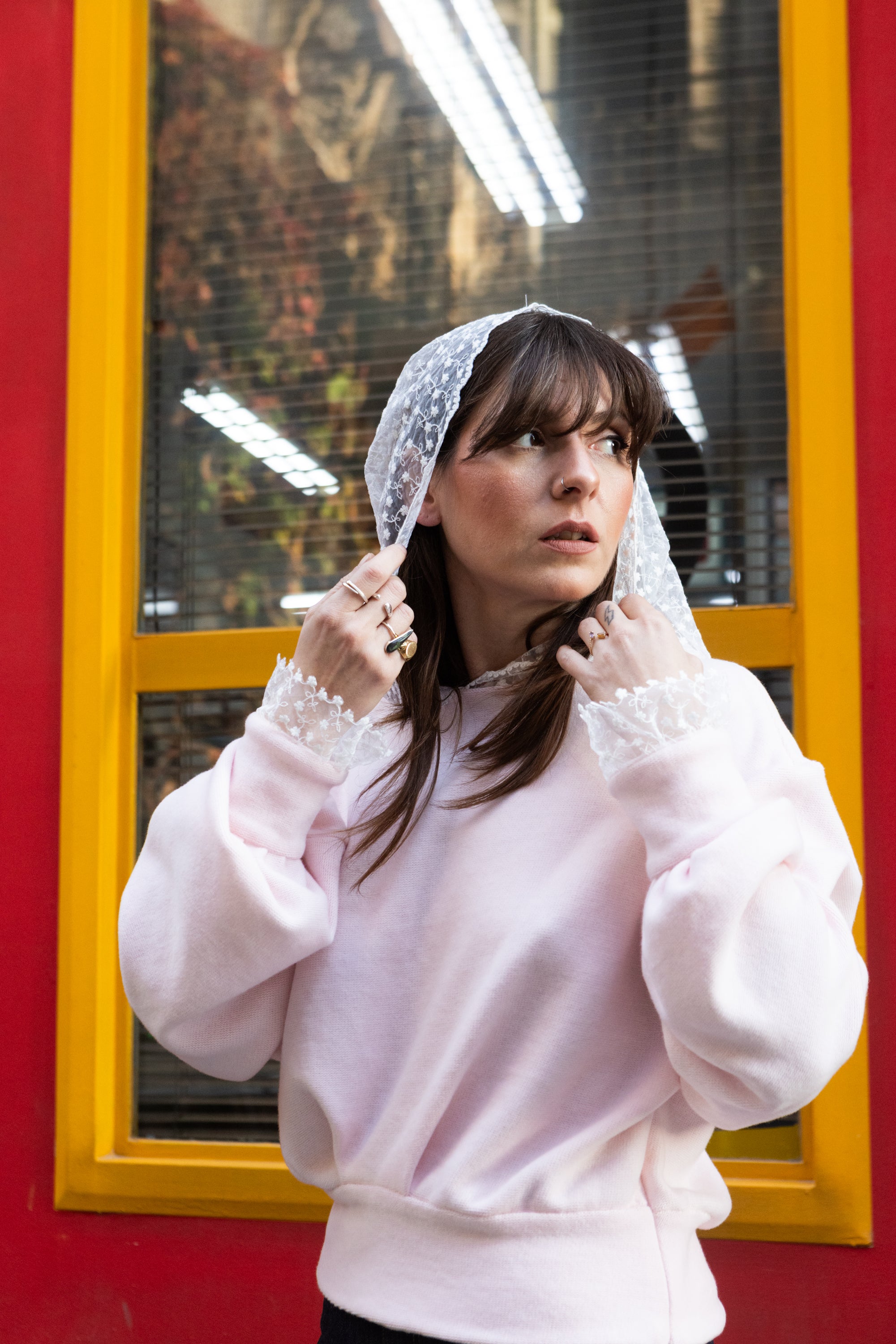 Soft pink cotton lace hoodie for women with lace hood detail, worn in an urban setting, Julia Valas