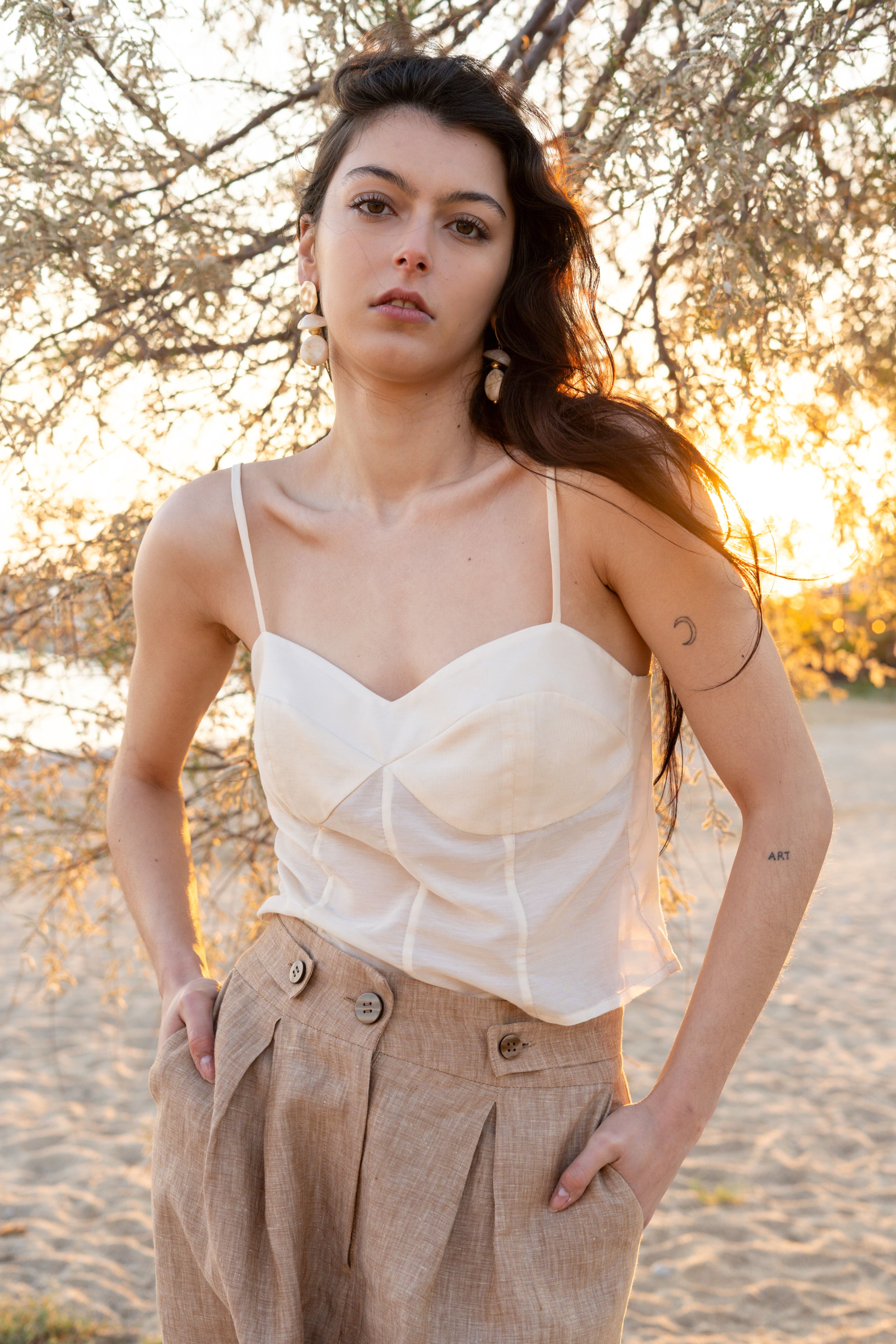 Sweetheart cotton silk bustier top with structured cups and thin straps paired with Smart Volume bermuda pants, high-waisted pleated tailored silhouette in lightweight natural fabric