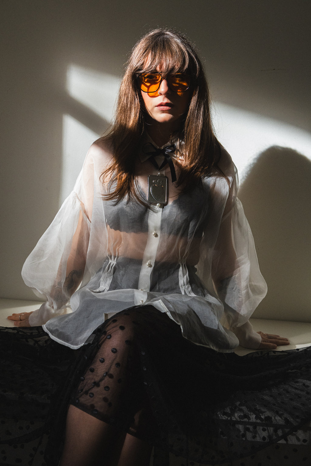 Sheer silk organza shirt with pearl buttons styled with black polka dot skirt, editorial light portrait, Julia Valas