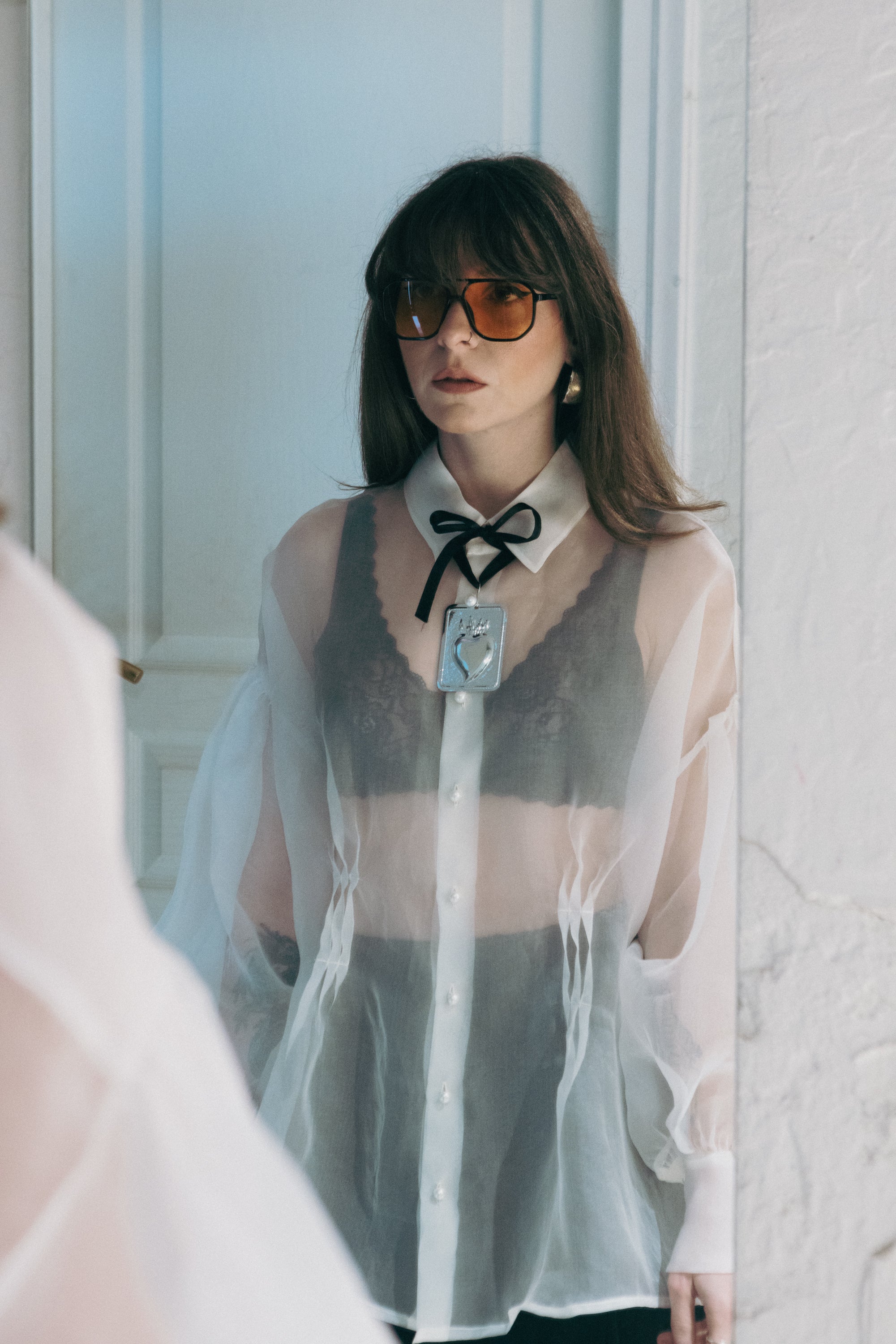 Sheer silk organza shirt with pearl buttons and structured collar, styled with neck bow detail and lace layering underneath, Julia Valas