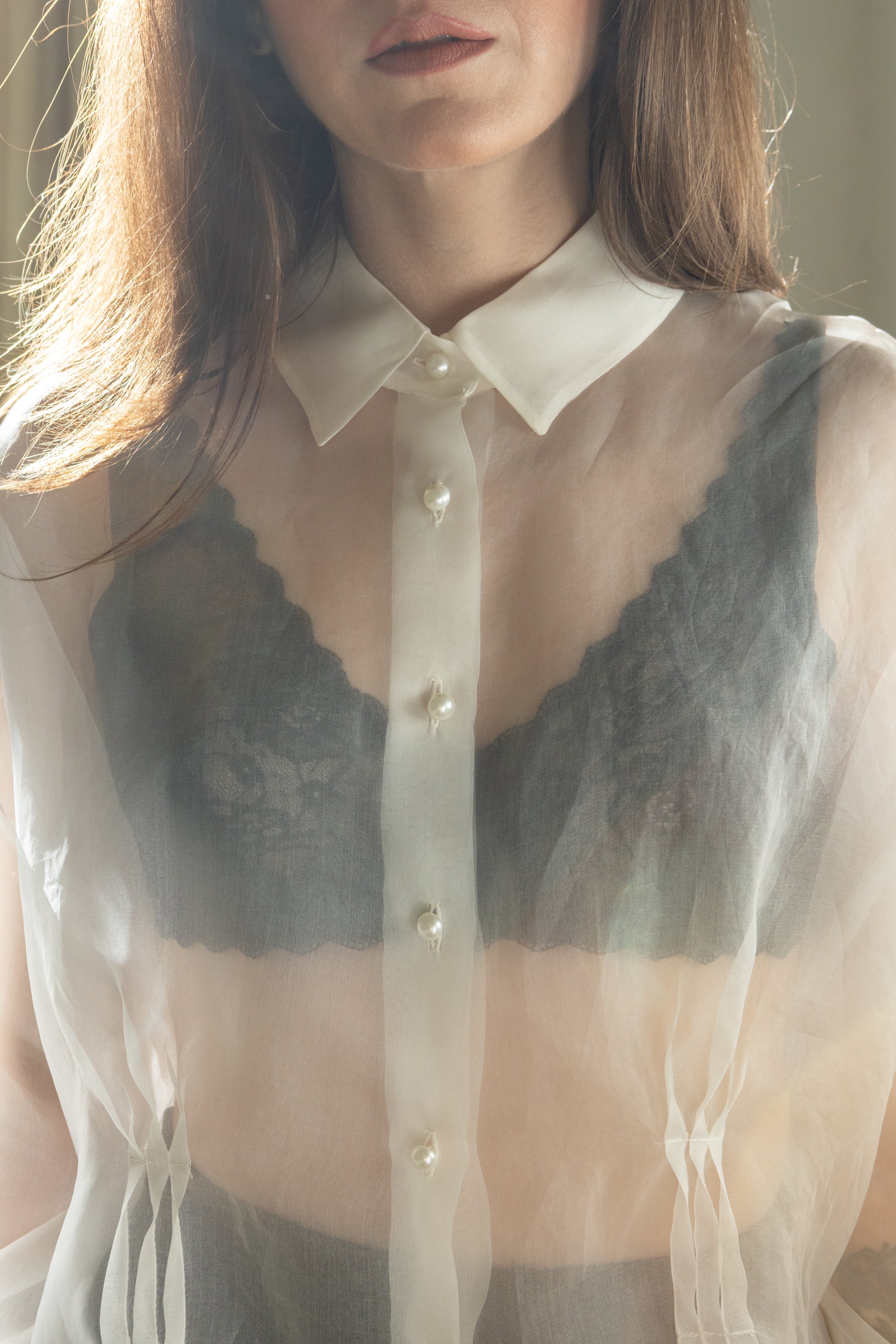 Close-up of sheer silk organza shirt with pearl buttons and structured collar, transparent fabric layered over lace bralette, Julia Valas
